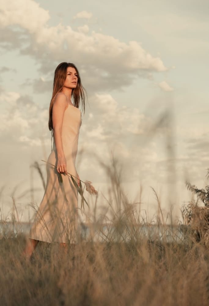 woman in a dress walking in a field 